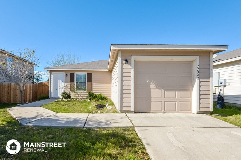 a small tan house with a white garage door