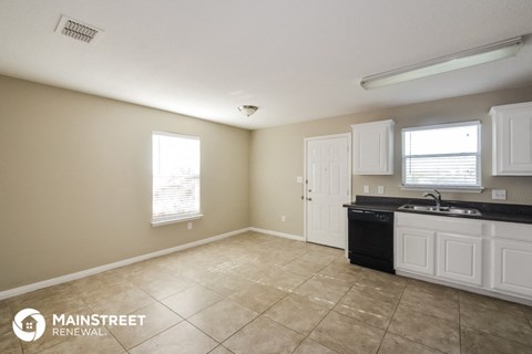 a kitchen with white cabinets and a sink and a counter top