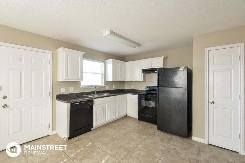 a kitchen with white cabinets and black appliances and a black refrigerator