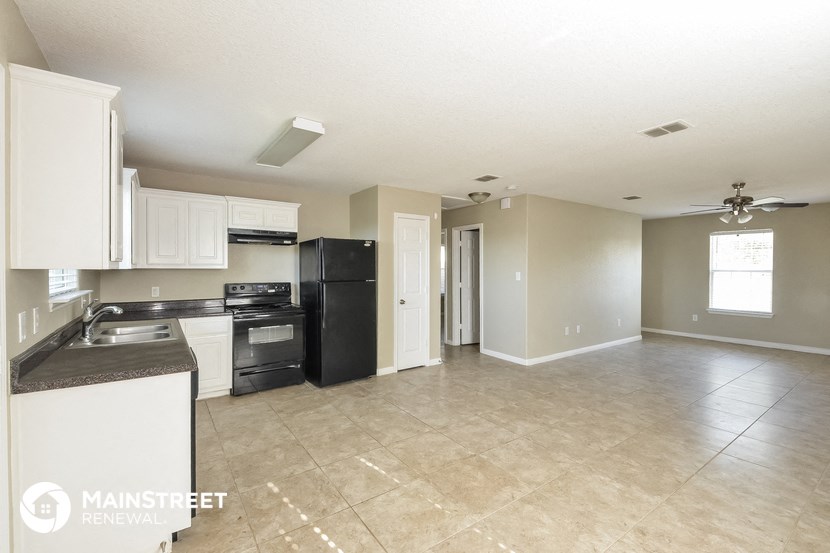 a kitchen with white cabinets and black appliances
