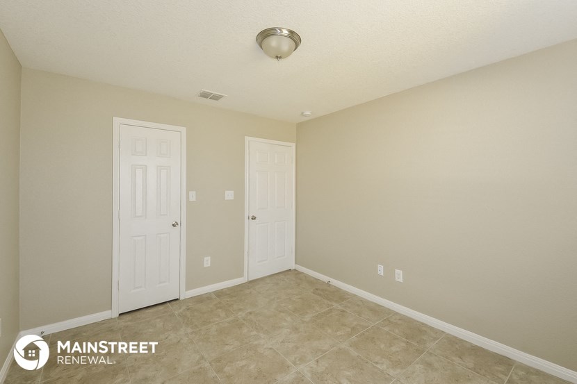 the spacious living room with two doors to the closet