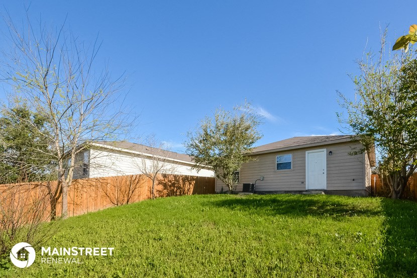 a small house with a yard and a fence