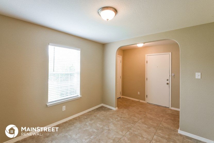 the spacious dining room with tile flooring and a large window