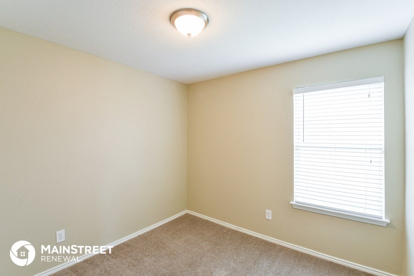 the upstairs bedroom has a large window and carpeted flooring