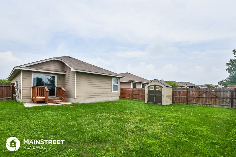 a home with a yard and a wooden fence