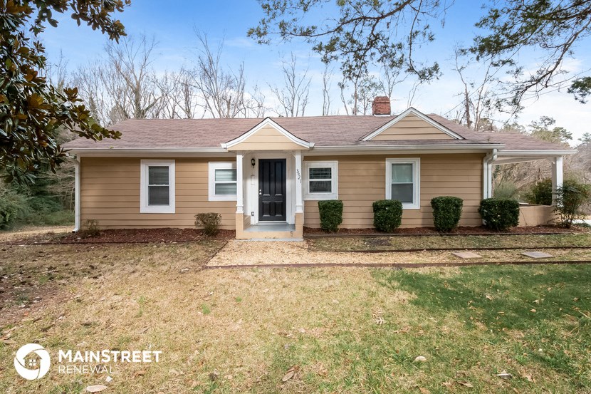 a small brown house with a lawn and a door