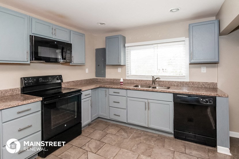 a kitchen with blue cabinets and black appliances