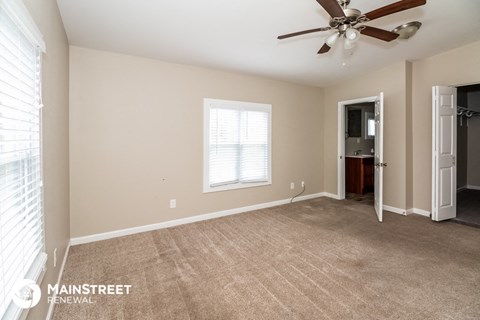 a living room with carpet and a ceiling fan