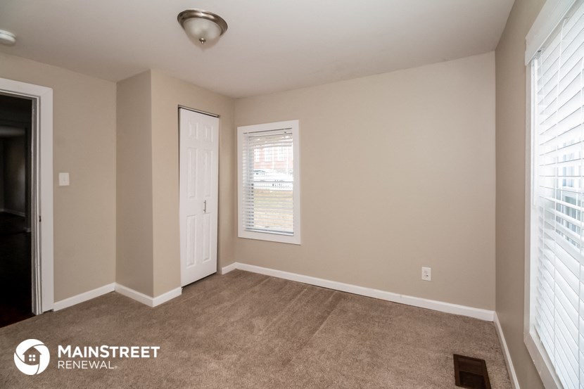the interior of an empty room with a door and window