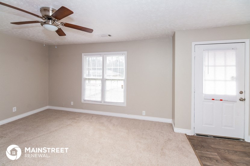a bedroom with a ceiling fan and a white door