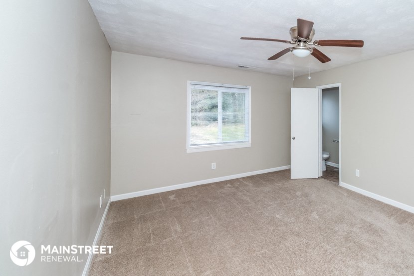 the living room of an empty house with a ceiling fan