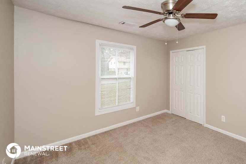 a bedroom with a ceiling fan and a white door