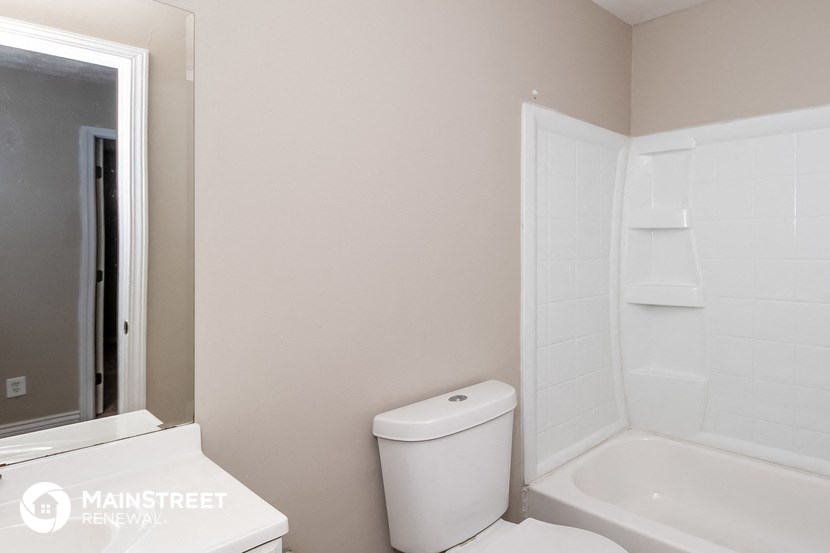 a bathroom with a toilet and a tub and a sink