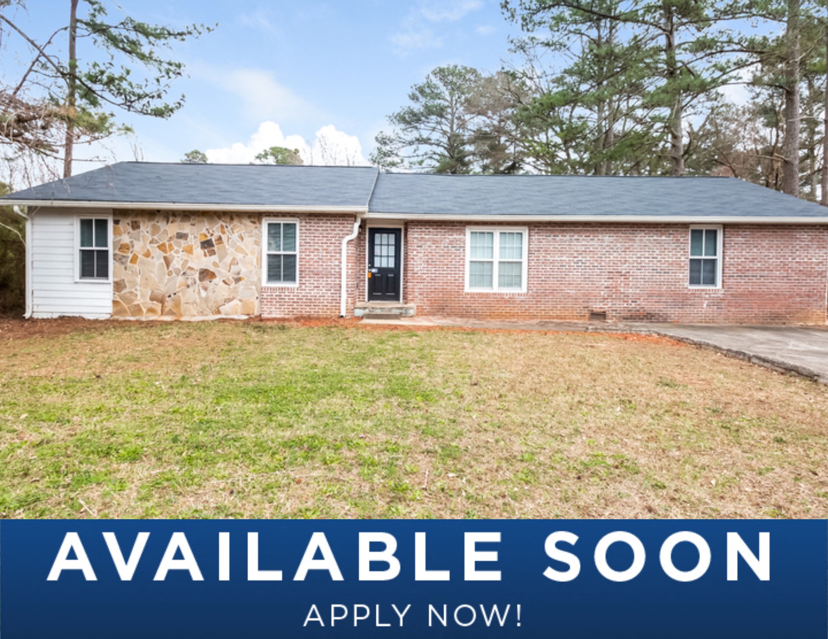a small brick house with a yard in front of it