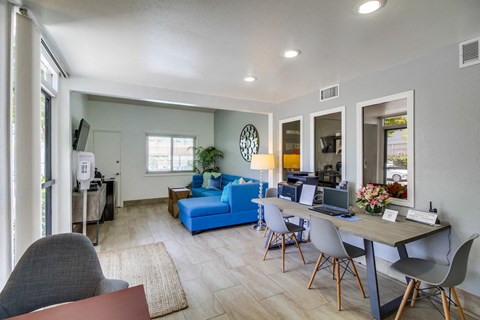 a living room and dining room with a table with a laptop