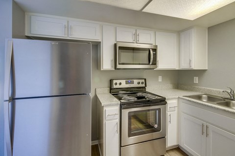 a kitchen with stainless steel appliances and white cabinets