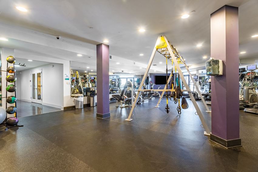a gym with weights and other exercise equipment in a building with white walls