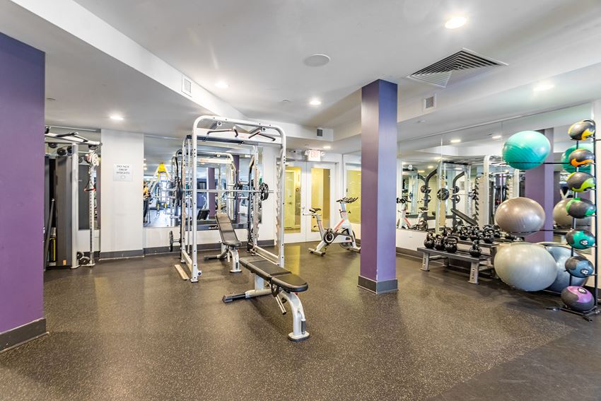 a gym with weights and other exercise equipment in a building with purple walls