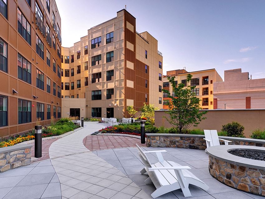 a patio with two white chairs in front of a building