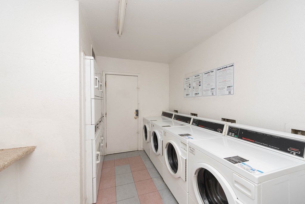 a washer and dryer room with washing machines and a door to a bathroom