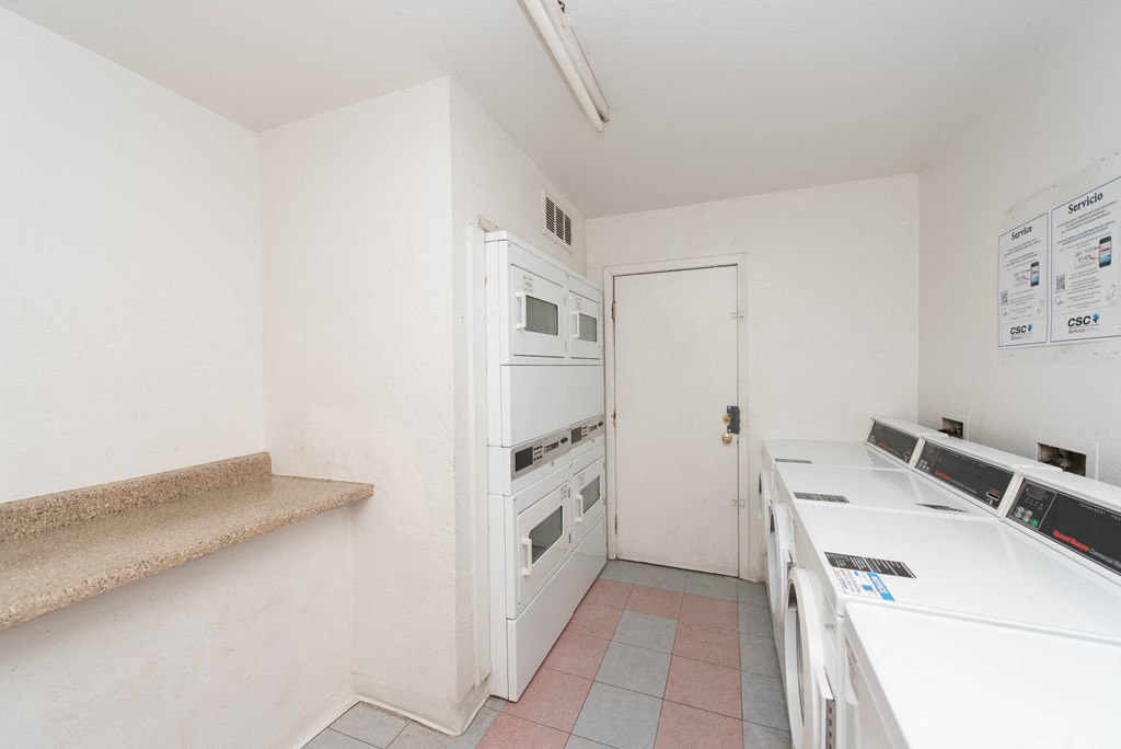 an empty kitchen with white appliances and a counter