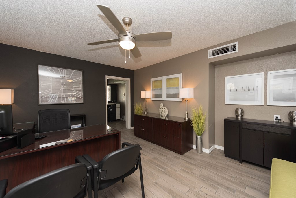 a living room with a ceiling fan and a desk