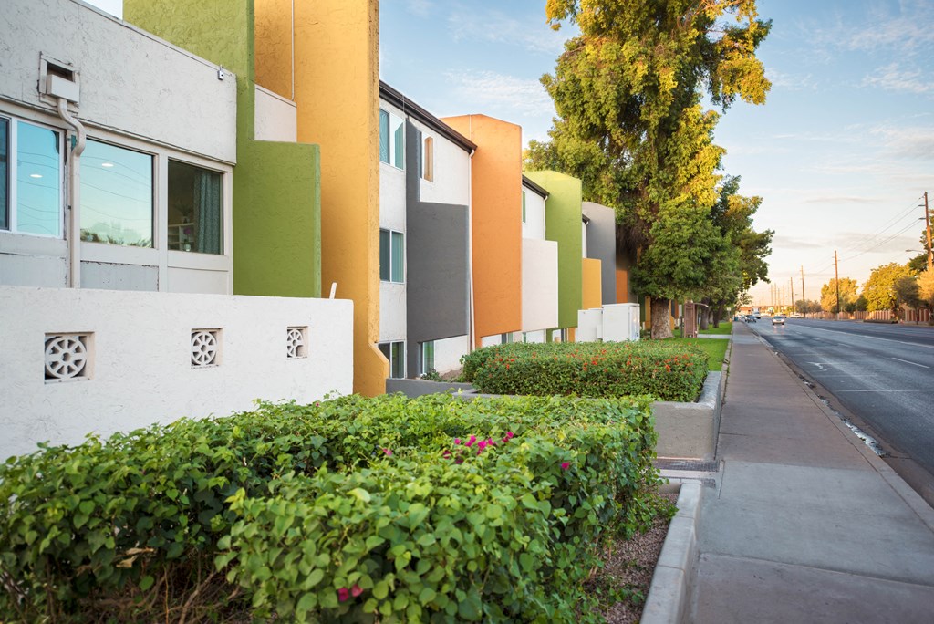 a row of apartment buildings with a street in the
