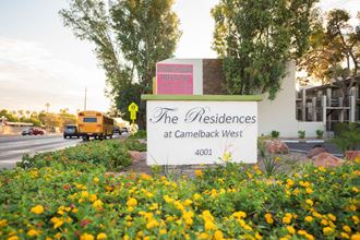 the residences at camelback west sign in front of building with yellow flowers