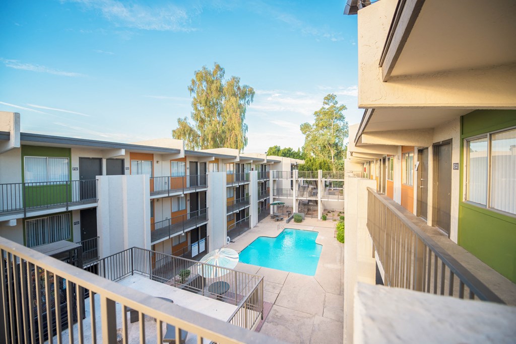 the view of a pool from a balcony of an apartment building