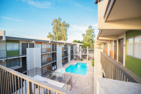 the view of a pool from a balcony of an apartment building