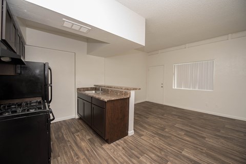 an empty kitchen and living room with a stove and refrigerator