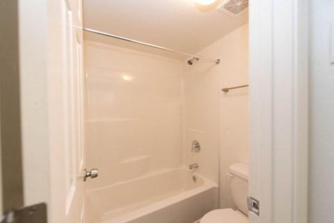 a white bathroom with a shower and a toilet