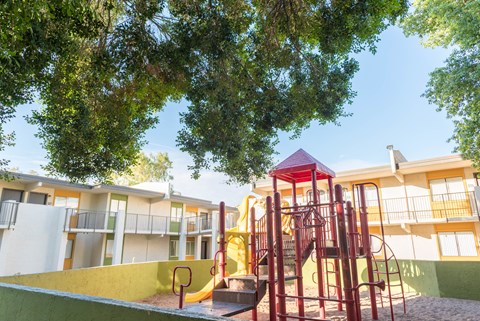 a playground at an apartment complex with a colorful play set