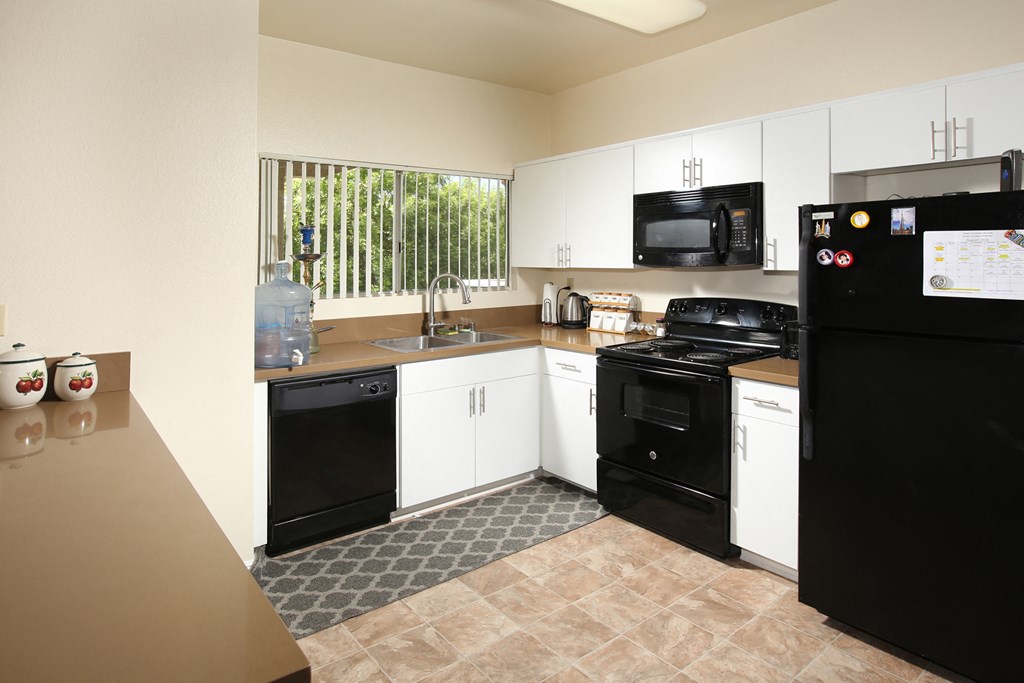 a kitchen with black appliances and white cabinets