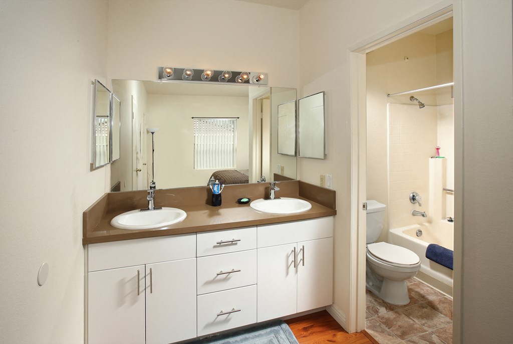 a bathroom with two sinks and a toilet and a shower