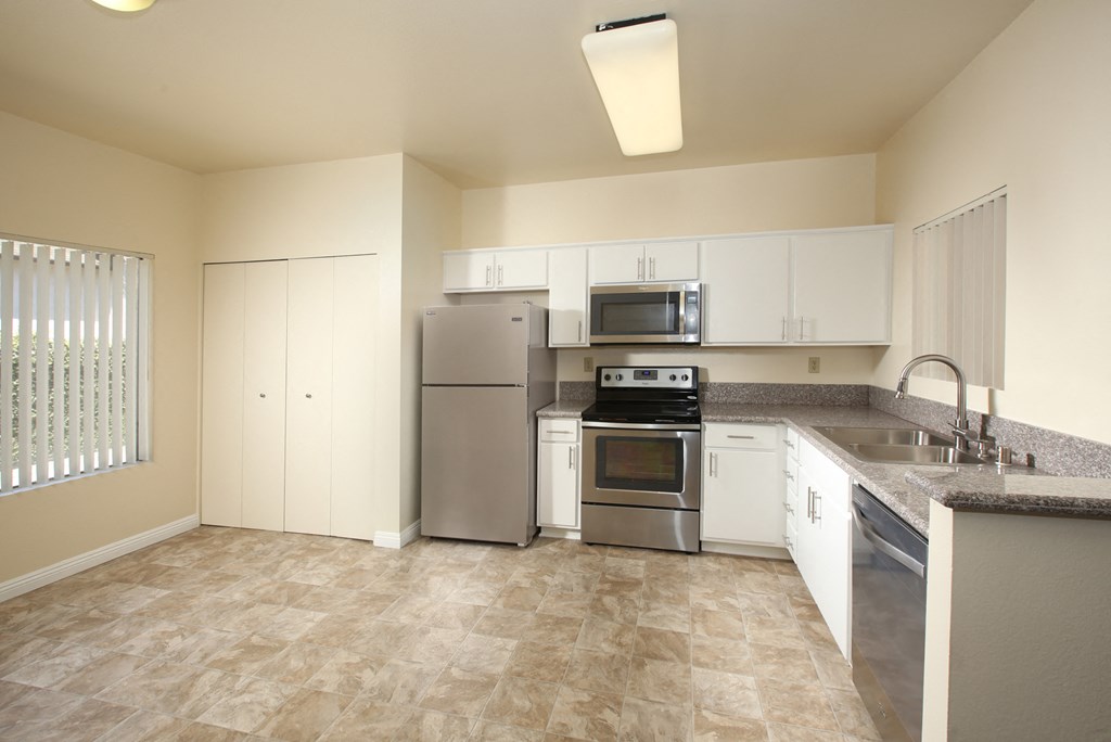 a kitchen with stainless steel appliances and white cabinets