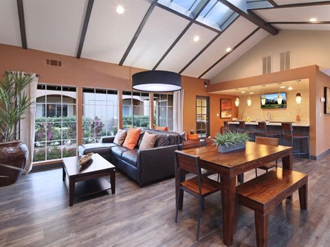 A modern living room with a black couch and a wooden table.