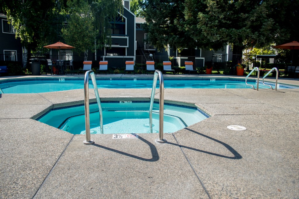 Apartments in Sacramento CA - Waterford Cove - Spa with Pool and Lounge Chairs in the Background