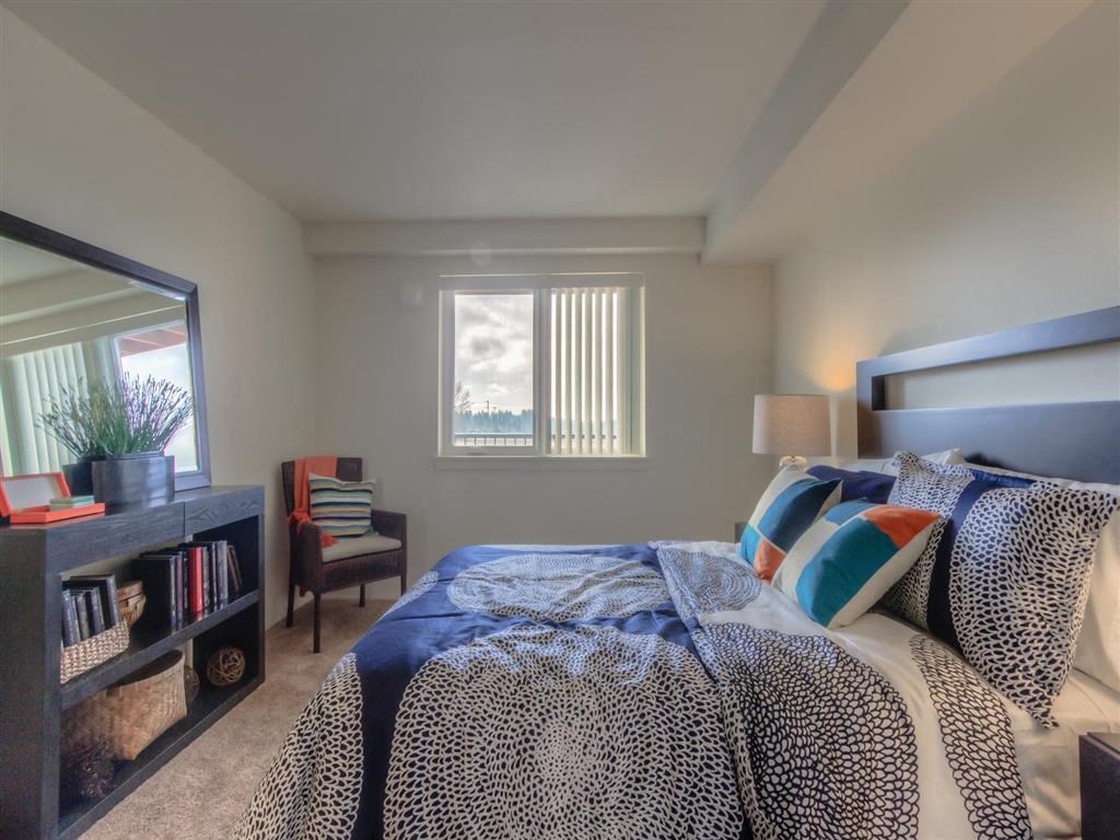 One, Two, and Three-Bedroom Apartments in Lynnwood, WA - Urban Center - Bedroom with Bed, Dresser, Chair, Nightstands, Lamps, and Window