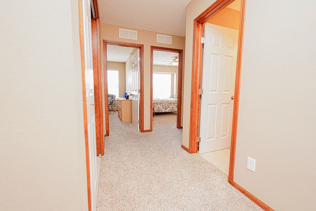 a bedroom with two closets and a hallway to a bedroom and a bathroom