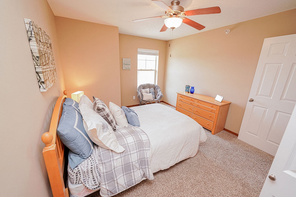 a bedroom with a bed and a ceiling fan