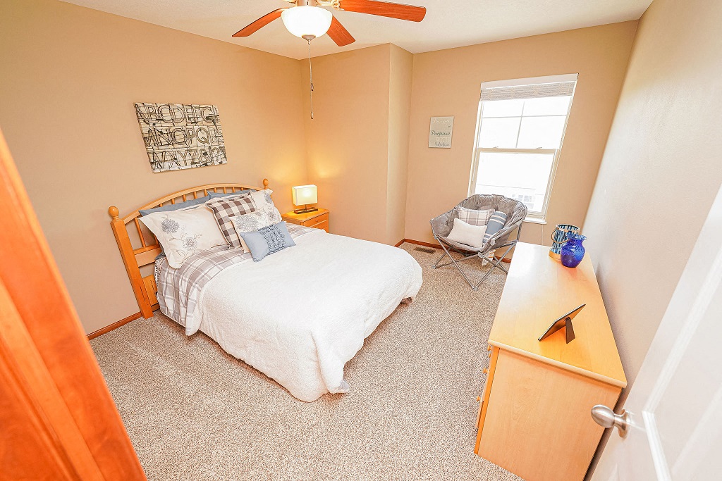 a bedroom with a bed and a desk and a window