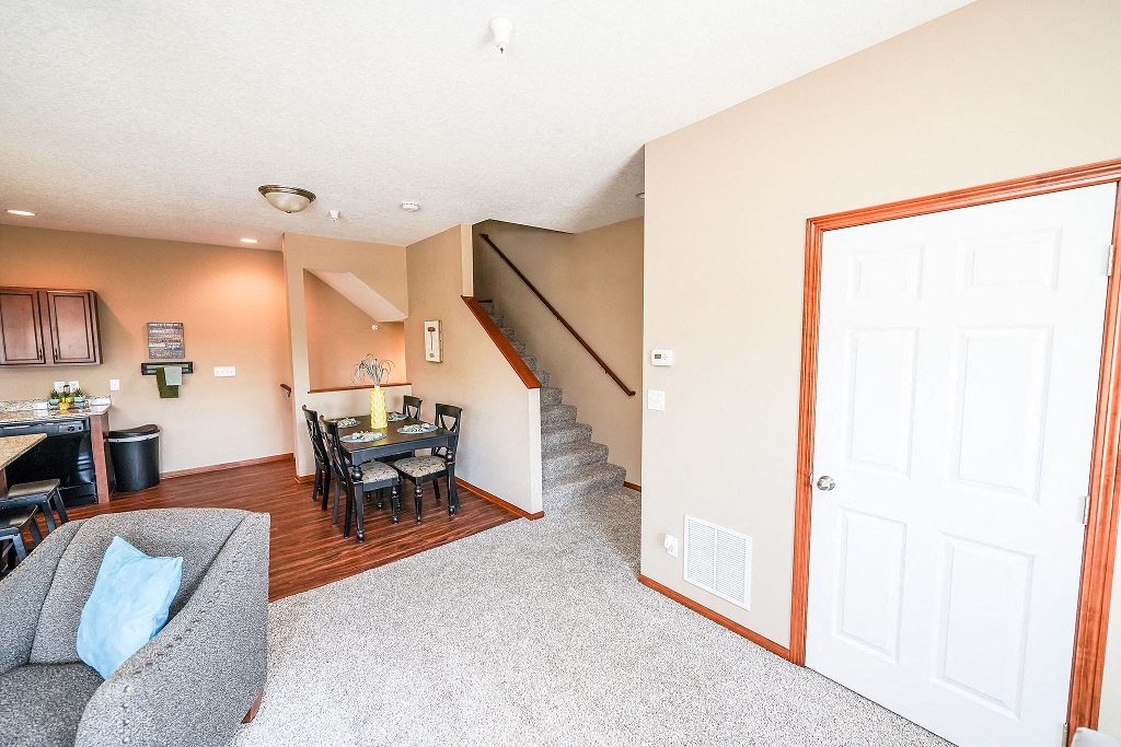 a living room and dining room with a staircase