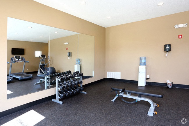 a gym with a large mirror and weights on the floor