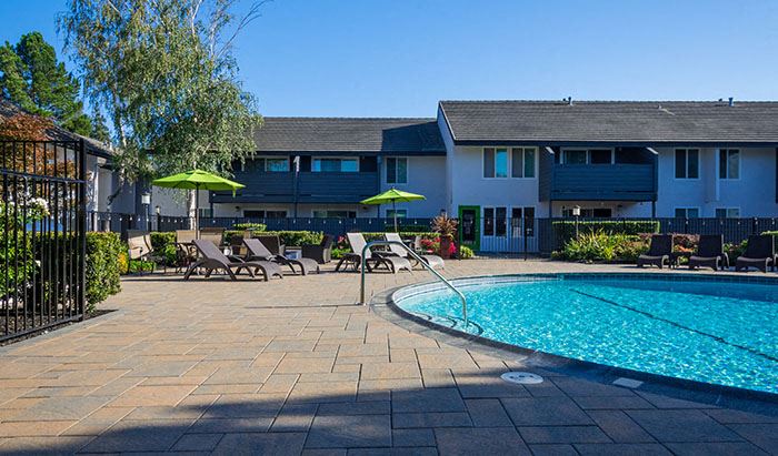 Apartments for Rent in Walnut Creek - The Meridian - Pool Area with Lounge Chairs, Green Umbrellas, and Tables - Photo Gallery 1