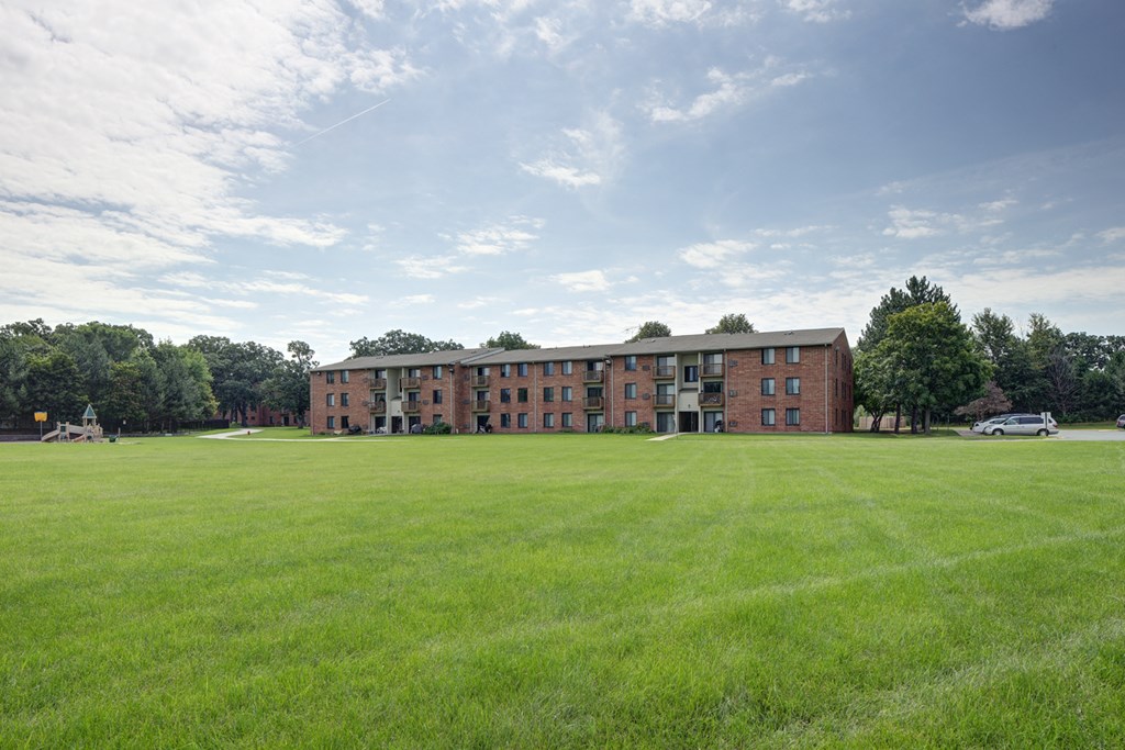 a large lawn in front of a brick building