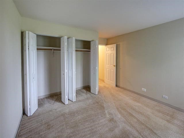 an empty living room with three doors in it