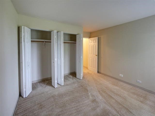 an empty living room with three doors in it