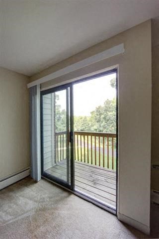 a living room with a balcony and a sliding glass door