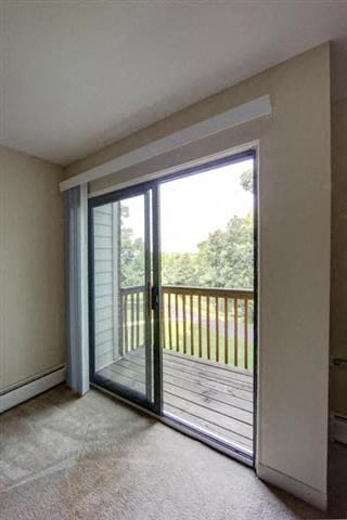a living room with a balcony and a sliding glass door